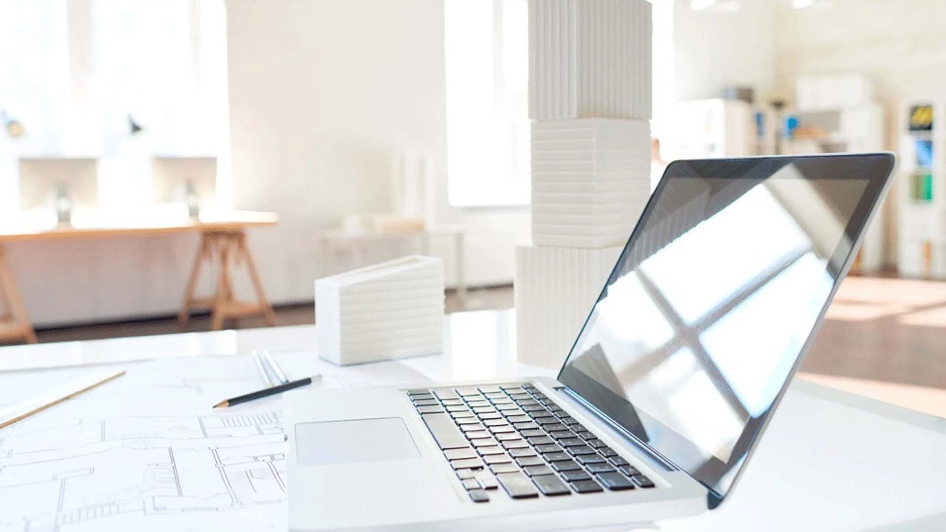 A laptop and a blueprint kept on the desk of a developer in Greater Vancouver