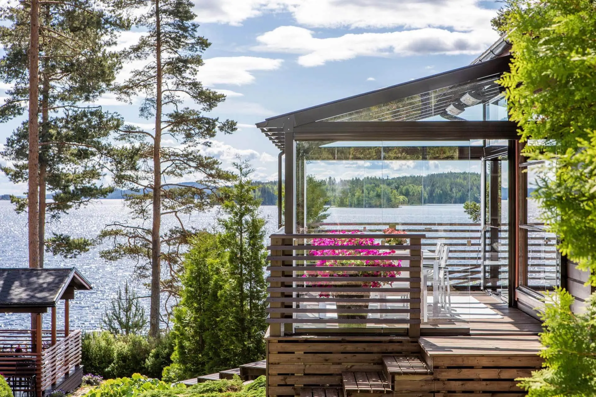 A wooden deck overlooking a lake featuring a glazed patio in Greater Vancouver and Greater Toronto