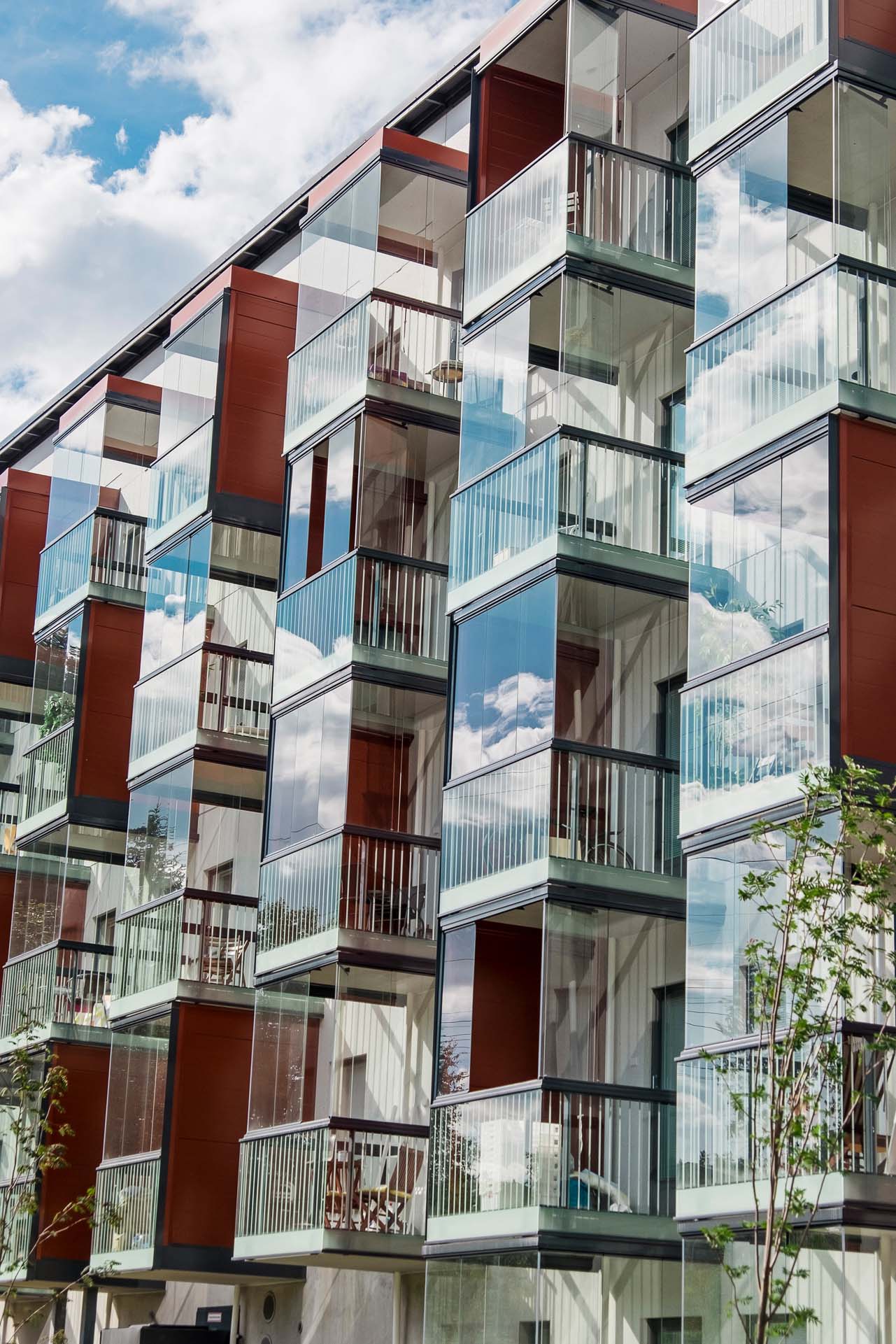 Blick auf eine Balkonfassade eines Mehrfamilienhauses mit verglasten Balkonen