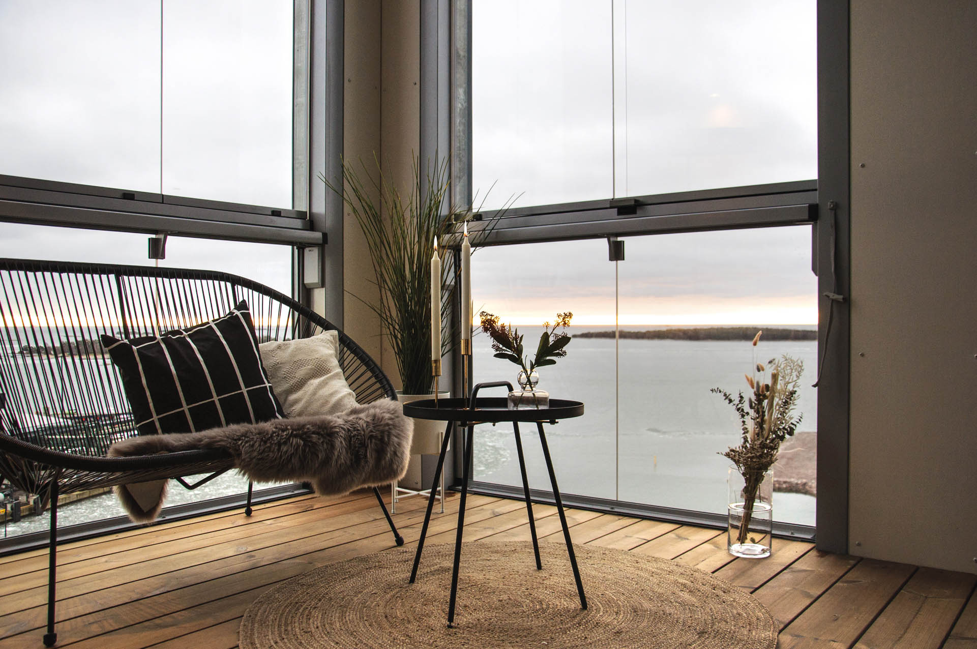 Sitzgelegenheit auf einem verglasten Balkon mit Blick aufs Meer