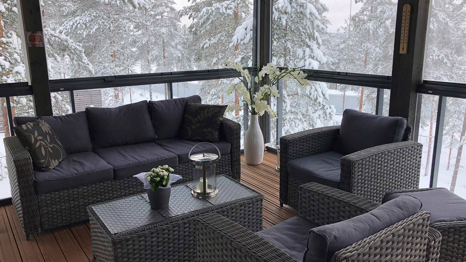 Verglaster Balkon mit Sitzmöbeln im Winter