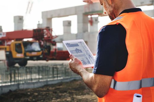 Bauleiter mit Tablett auf Baustelle