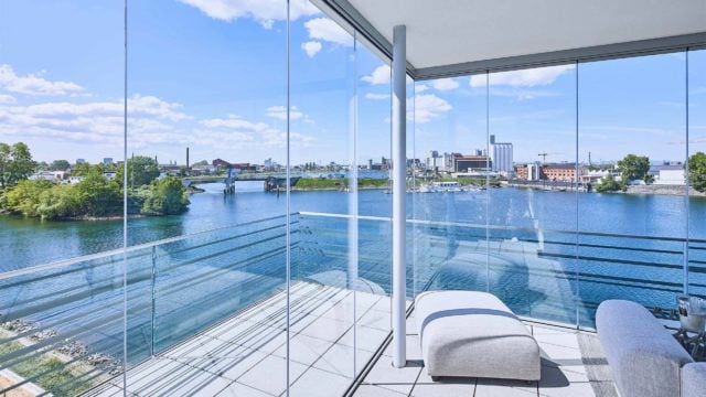 Couchlandschaft auf verglastem Balkon mit Blick auf den Fluss