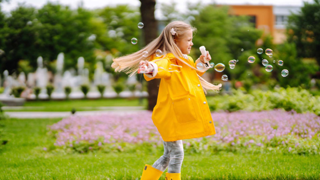 Petite fille mignonne en automne lors d'une promenade soufflant des bulles de savon. Enfance, repos actif, concept de style de vie.