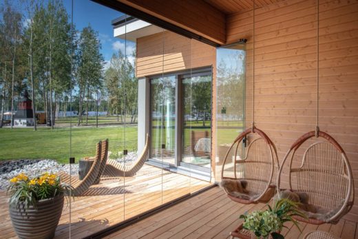Deux fauteuils suspendus sur une terrasse avec vitrage de terrasse Lumon