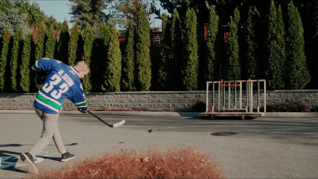 Eishockeyspieler schlägt Puck auf Balkonverglasung