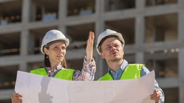 Mann und Frau auf einer Baustelle im Gespräch