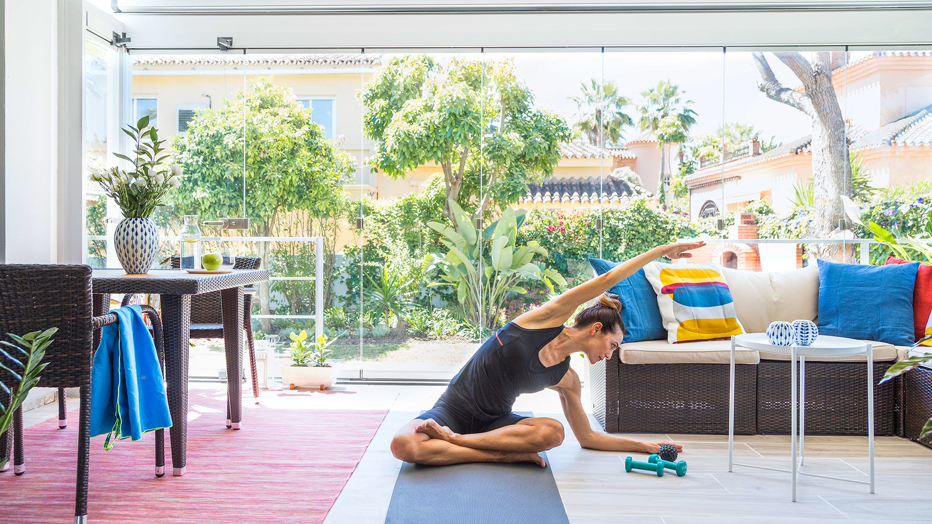 Frau Beim Yoga auf ihrer verglasten Terrasse
