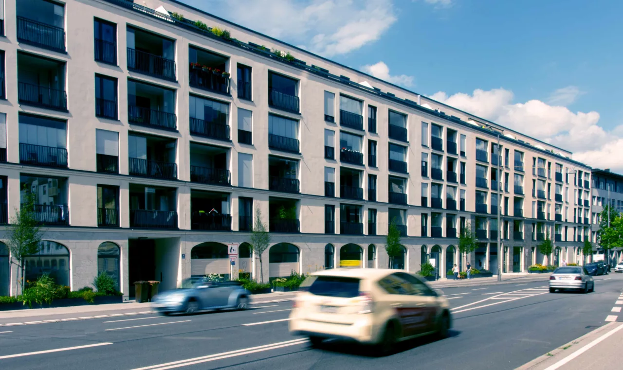 Mehrfamilienhaus an verkehrsreicher Straße durch Balkonverglasungen vor Straßenlärm geschützt