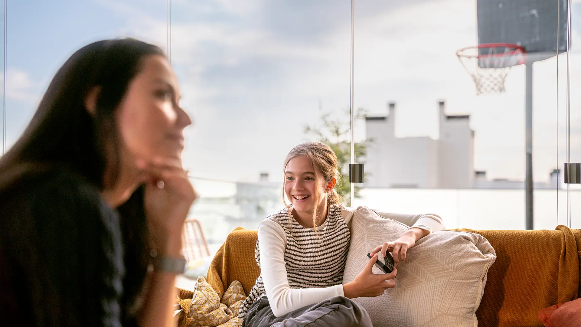Eine Frau und ein Mädchen sitzen auf einem Balkon mit Balkkonverglasung