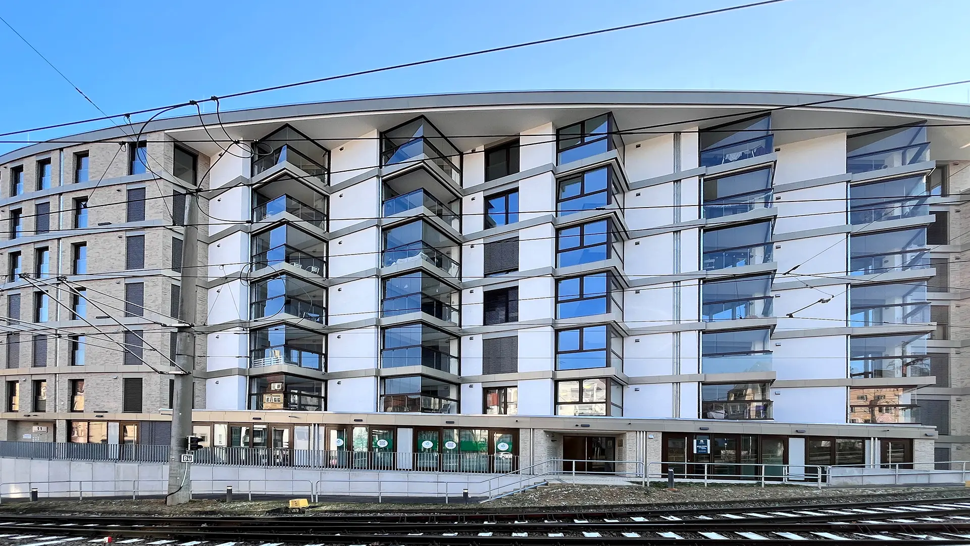 Mehrfamilienhaus mit Balkonen zur Straßenbahn raus. Der Lärmschutz wird durch Balkonverglasungen gewährleistet.