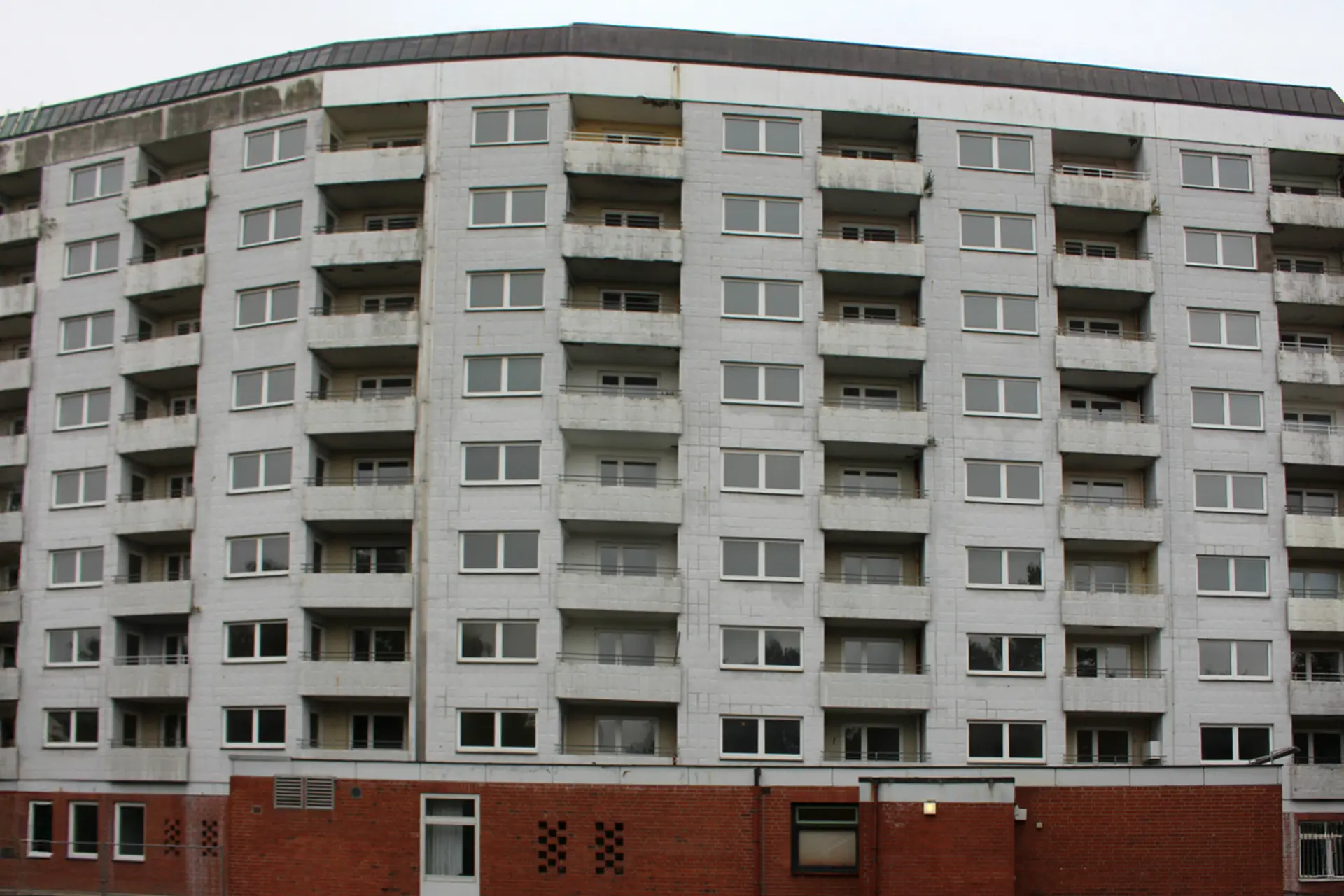 Sanierungsbedürftiges Mehrfamilienhaus mit bröckelndem Putz