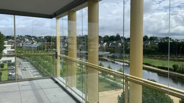 Blick von einem Balkon mit Balkonverglasung auf einen Fluss