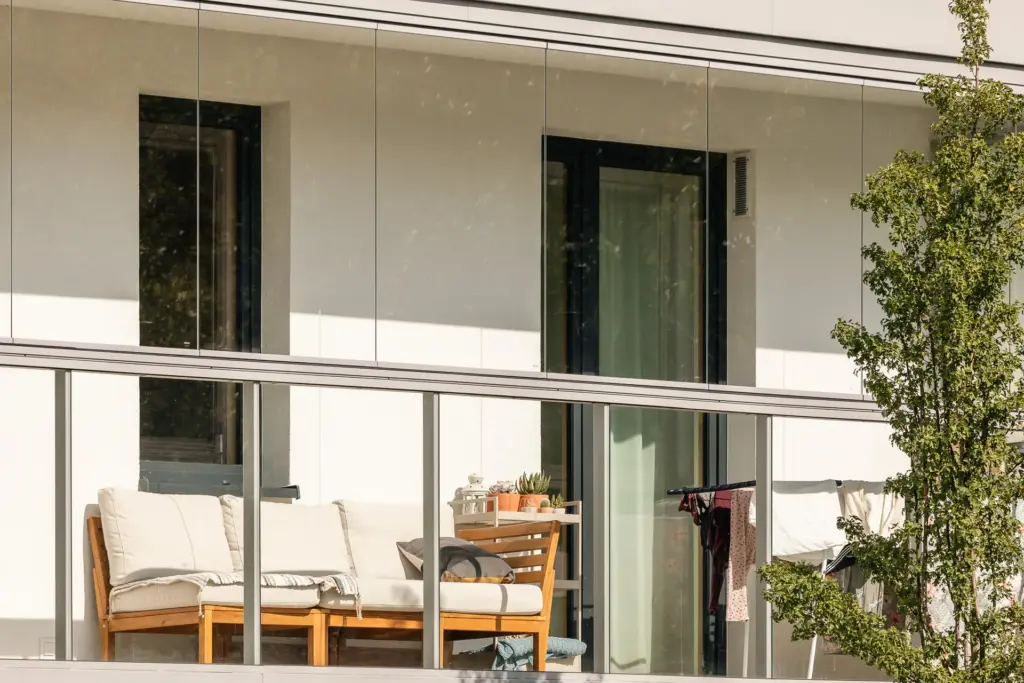 Blick auf einen möbilierten Balkon mit Verglasung