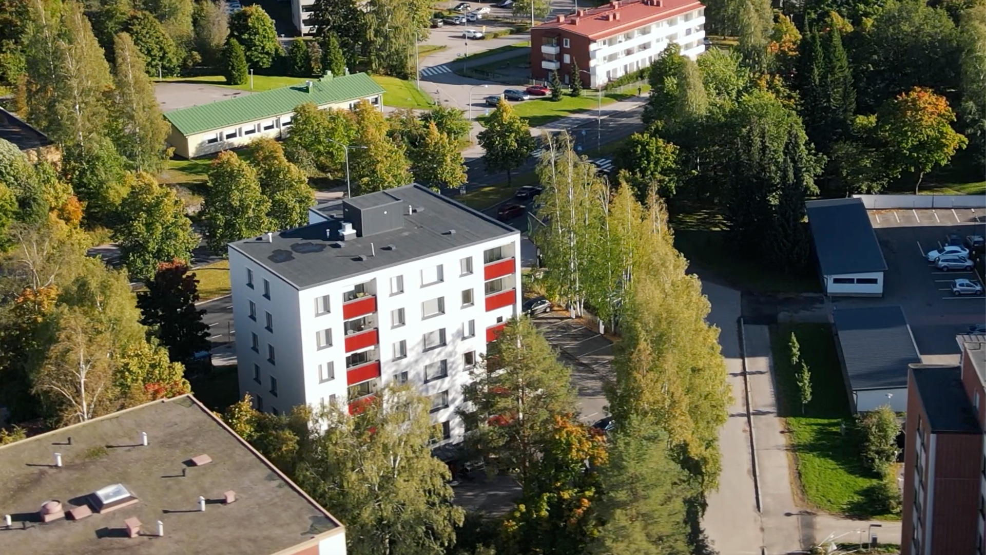 Lumon parvekejulkisivu parvekelaseilla ja punaisilla lasikaiteilla
