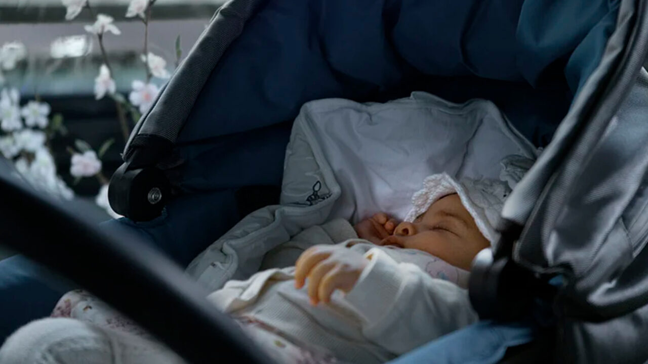 vauva nukkumassa rattaissa lasitetulla terassilla