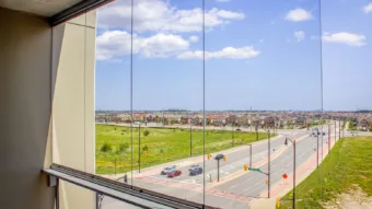 Vue depuis un balcon vitré devant lequel circulent de nombreuses voitures.