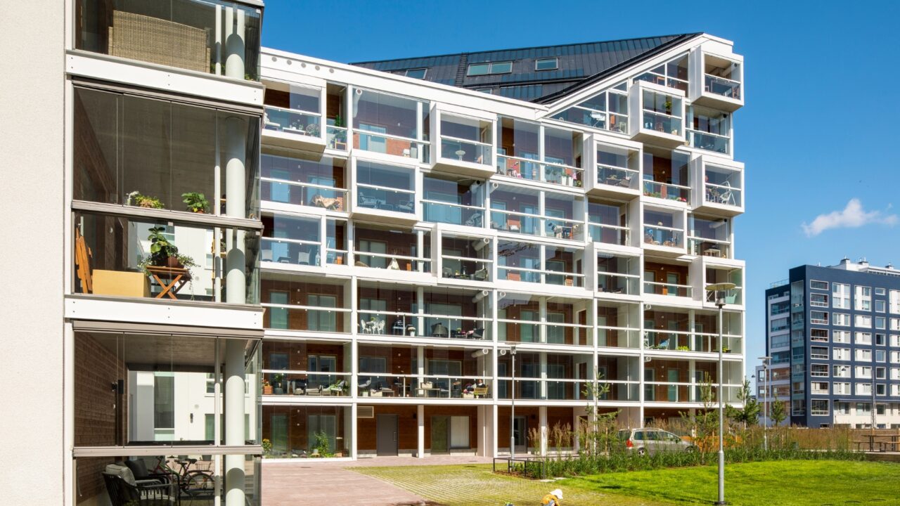 Multi-residential building with balconies enclosed in balcony glazing on a sunny day